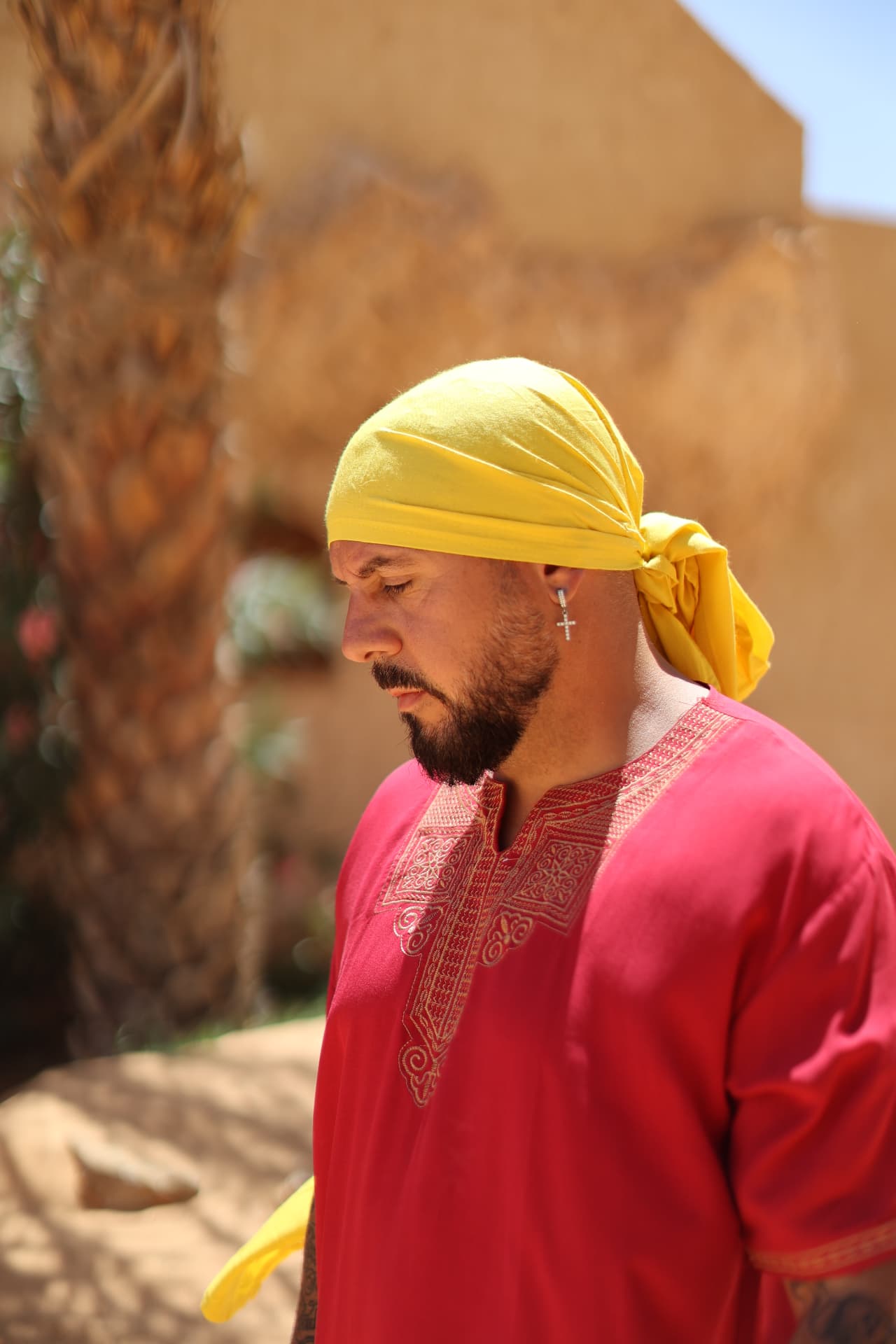 Marc Isla, foulard jaune et tunique rouge brodée, sous le soleil