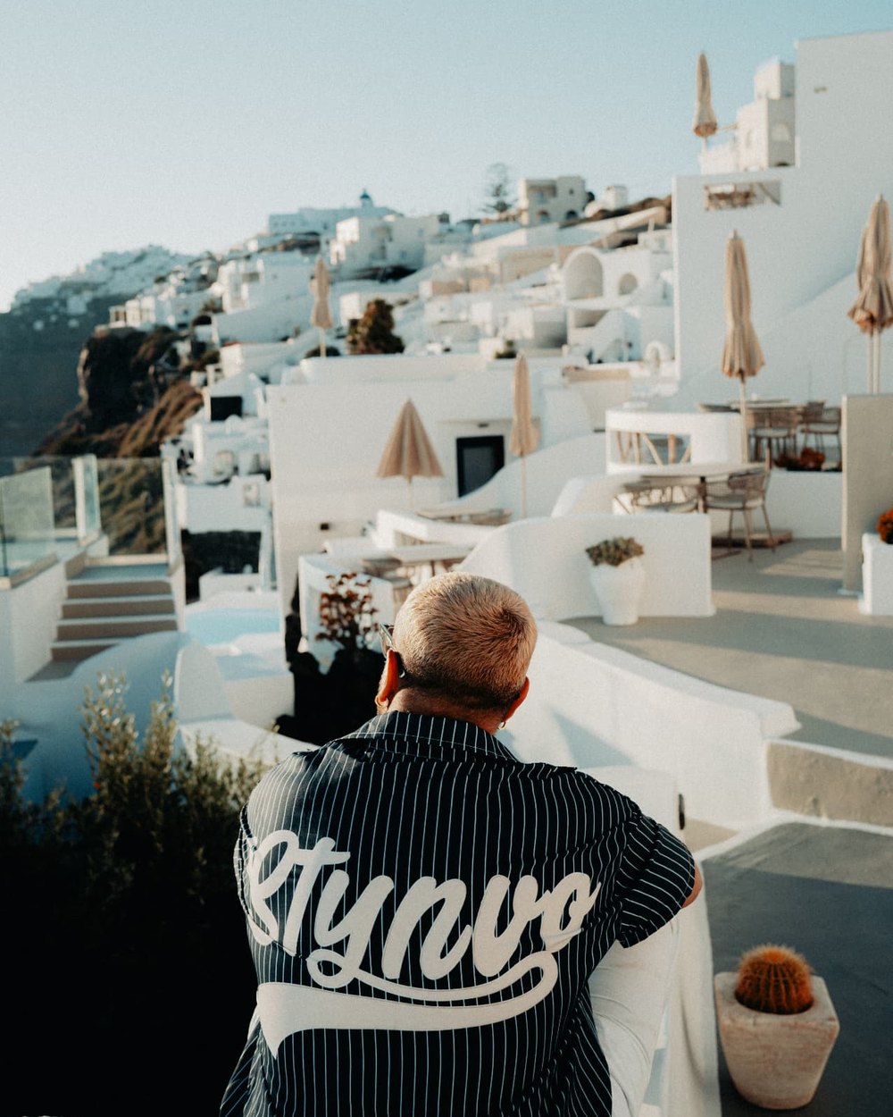 Marc Isla, de dos, face à une vallée en terrasses baignée de soleil